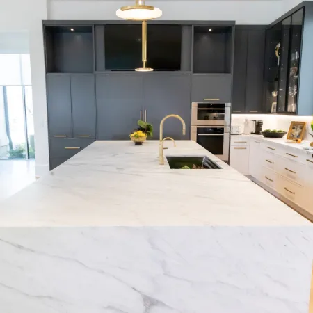 Modern kitchen featuring a marble island, sleek cabinetry, and elegant lighting fixtures.