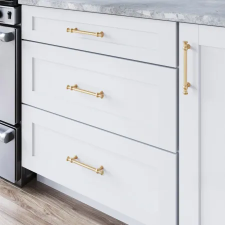 a white dresser with a gold handle