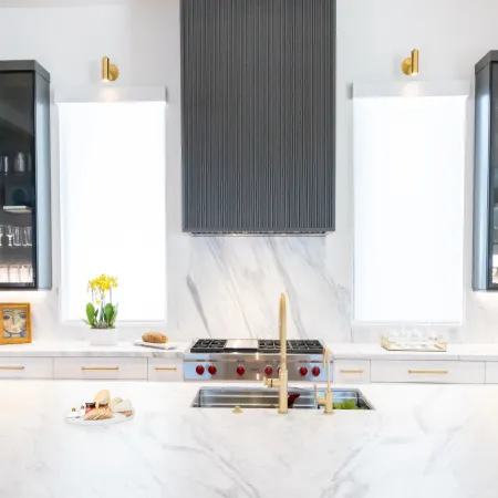Modern kitchen with marble countertops, sleek appliances, and stylish lighting, showcasing elegance and functionality.