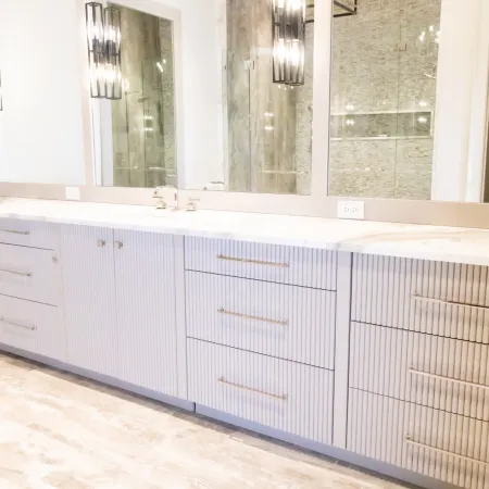 Modern bathroom vanity with sleek cabinetry and bright mirrors enhancing the space's elegance.