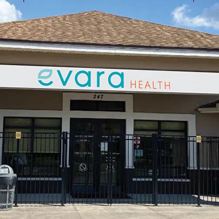 Evara Health sign with teal and orange text displaying contact number and slogan in outdoor setting