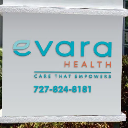 Evara Health sign displaying company name, tagline Care That Empowers, and phone number 727-824-8181 outdoors.