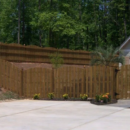 a fenced in yard with a wood fence and trees in the background