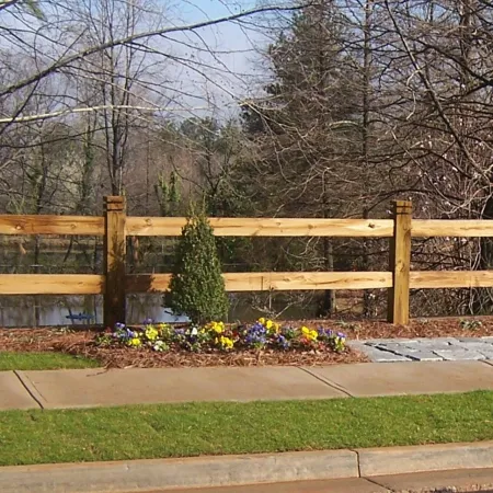 a wooden fence with flowers and grass