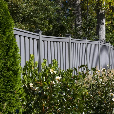 a white fence with trees and bushes around it