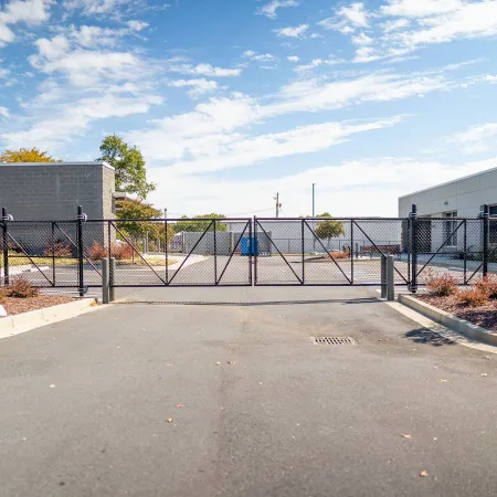 a fenced off area with a gate and a building in the background