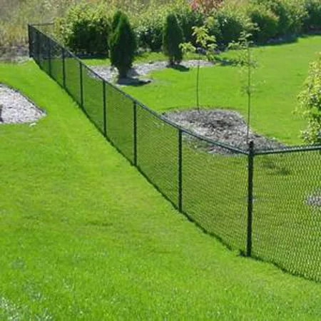 a fenced in yard with a tree and a small pond