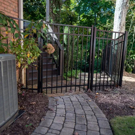 a gated yard with a metal gate and a brick wall