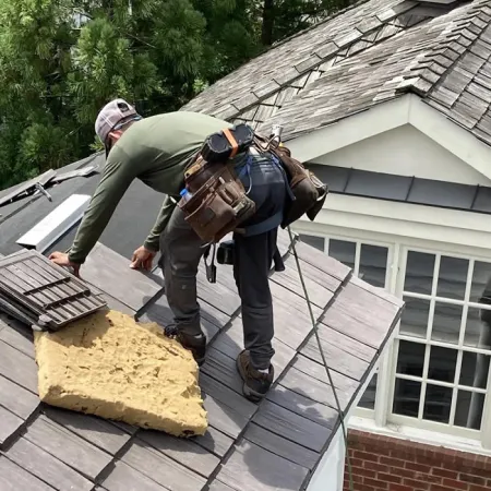 a couple of men working on a roof