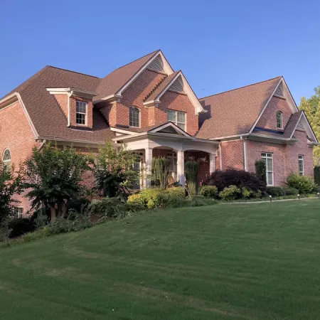 a large brick house with a lawn in front of it