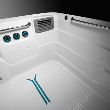 Clean white modern bathtub interior with jet nozzles, grab bars, and non-slip blue floor pattern.