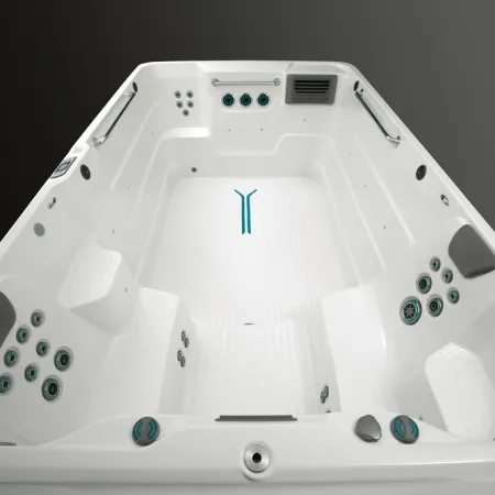 Top view of a modern white swim spa with multiple water jets, seating areas, and handles for support.