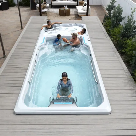 Family enjoying a swim spa with separate hot tub section on outdoor wooden deck patio.