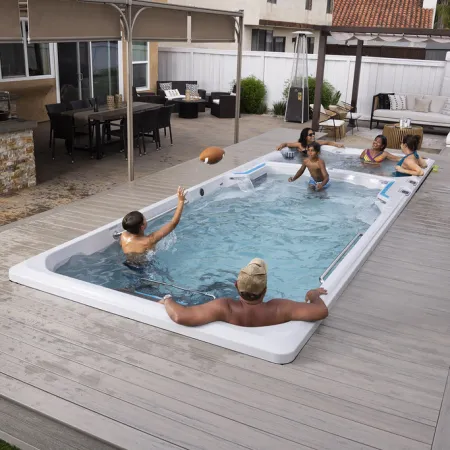 Family enjoying a swim spa in a modern backyard with seating and a covered patio area.
