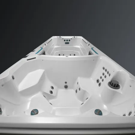 White luxury swim spa with built-in seats and multiple jets isolated on gray background