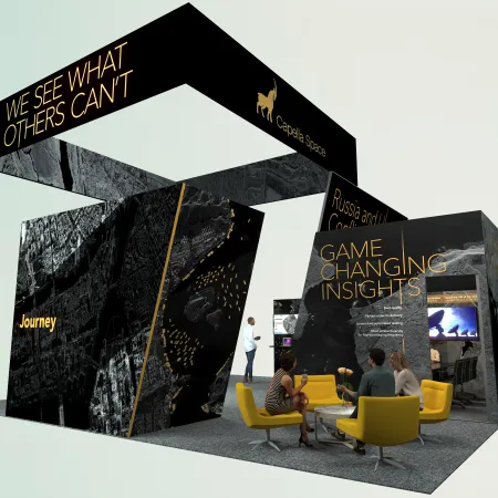 Modern exhibition booth with black and gold design, seating area, and bold text highlighting insights and journey.
