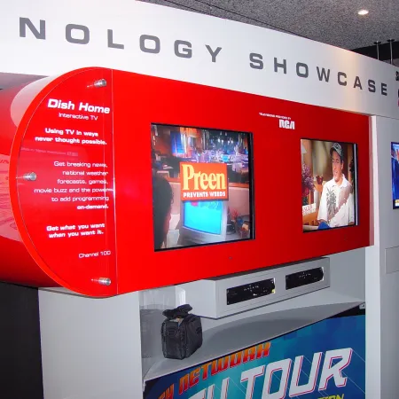 Red and white technology showcase display featuring multiple TV screens and Dish Home interactive TV promotional text.