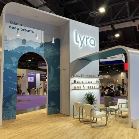 Modern Lyra booth with blue ocean-themed archway and seating area at a trade show event.