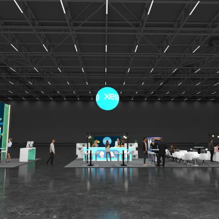 Modern trade show booth with Xero branding, digital displays, seating area, and visitors in a large hall.