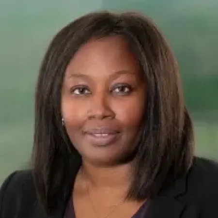 Portrait of a professional Black woman with shoulder-length hair wearing a black blazer and necklace