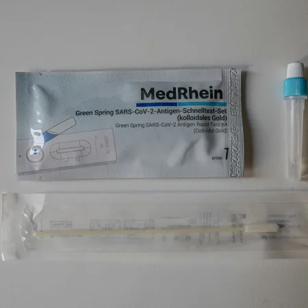 MedRhein Green Spring SARS-CoV-2 antigen rapid test kit with swab and reagent tube on a white surface.