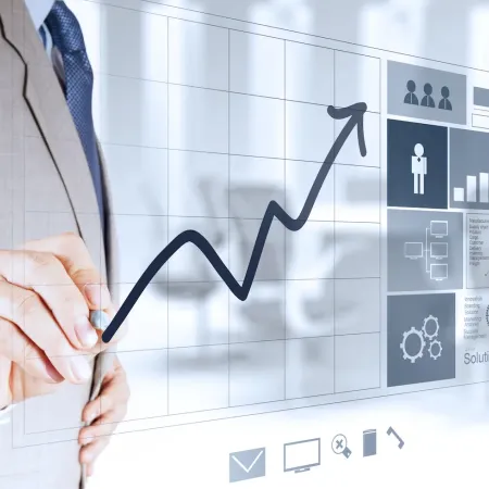 Businessman drawing an upward growth chart on a transparent digital interface with analytics and icons.