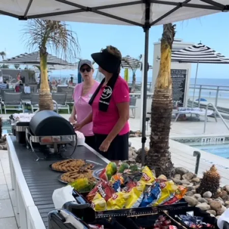 a person standing next to a grill with food on it