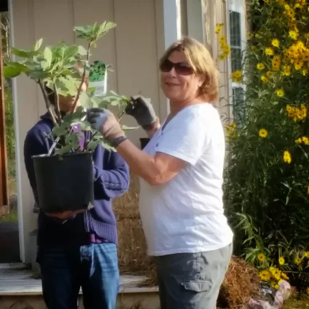 a man and a woman holding plants