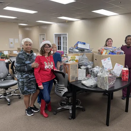 a group of women standing in a room with boxes and a table