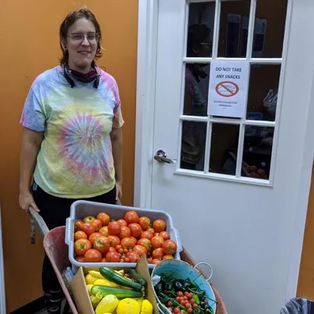 Laura Ferraiuolo standing next to a table full of fruits