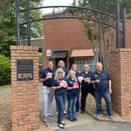 a group of people posing for a photo in front of a brick building