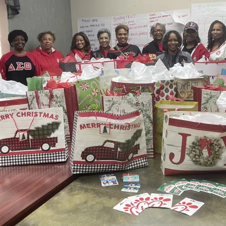 a group of people posing for a photo with a group of decorated boxes