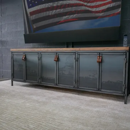 Industrial metal sideboard with wooden top and leather handles in modern living room under American flag.