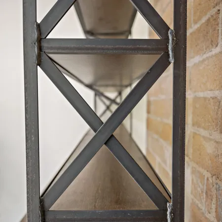 Close-up of industrial metal shelving with wooden shelves and brick wall background in soft focus.