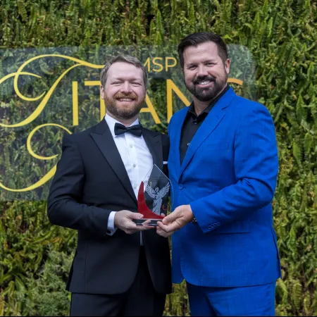 two men in suits holding a trophy