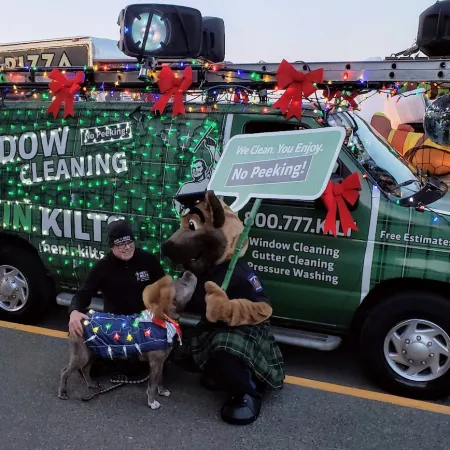 a person and a dog sitting in front of a green truck