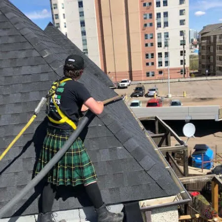 a person wearing a kilt and playing a guitar on a roof