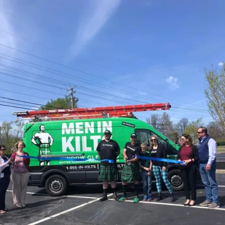 a group of people standing next to a green truck