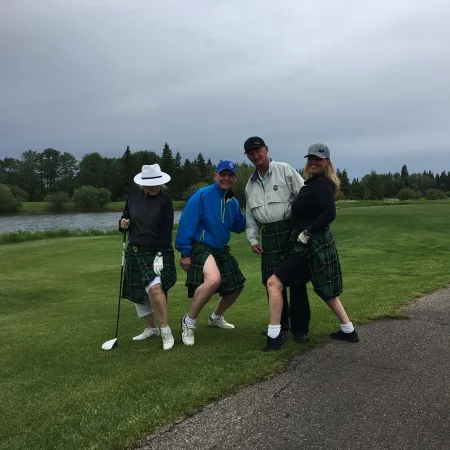 a group of people posing for a photo on a golf course