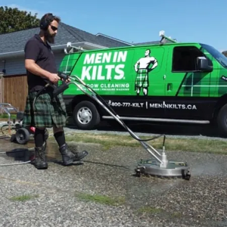 a man with a hose attached to a green van