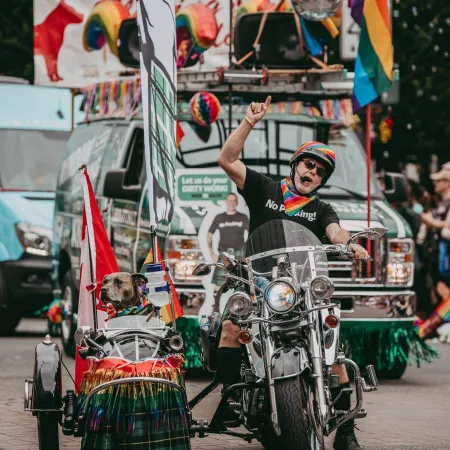 a person riding a motorcycle with a cart full of flags