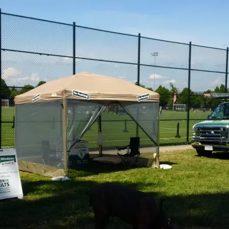 a green truck parked next to a white tent