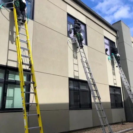 a person on a ladder painting a building