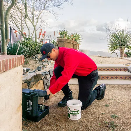 a man squatting down and holding a bucket of water