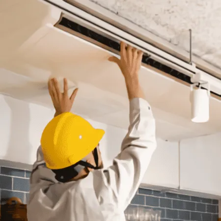 a man wearing a hard hat and holding his hands up