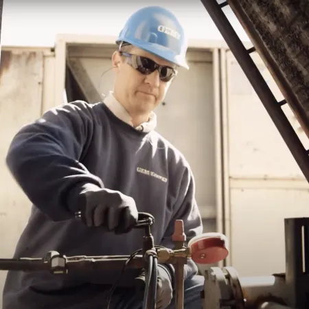 a man wearing a hard hat and sunglasses holding a metal rod