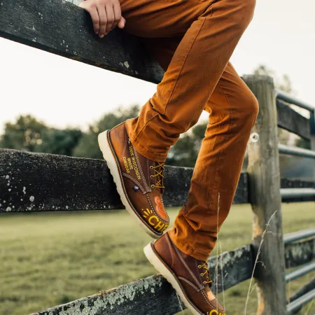 a person wearing a pair of brown shoes and jeans