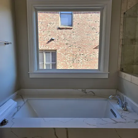 a bathtub with a window above it