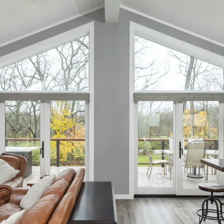 A living room with a sliding glass door onto the balcony on either side of the support post and special shape triangle Infinity from Marvin windows