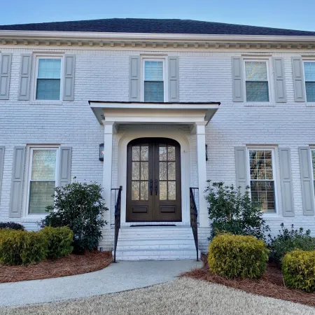 White brick house with custom double front entry doors 